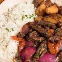 Lomo Saltado · Gluten free. Tender steak strips sautéed with onions and bright tomatoes in a red wine sauce...