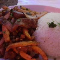 Lomo Saltado Entrée · Peruvian style seasoned beef strips grilled with onions, peas, tomatoes, and french fries se...