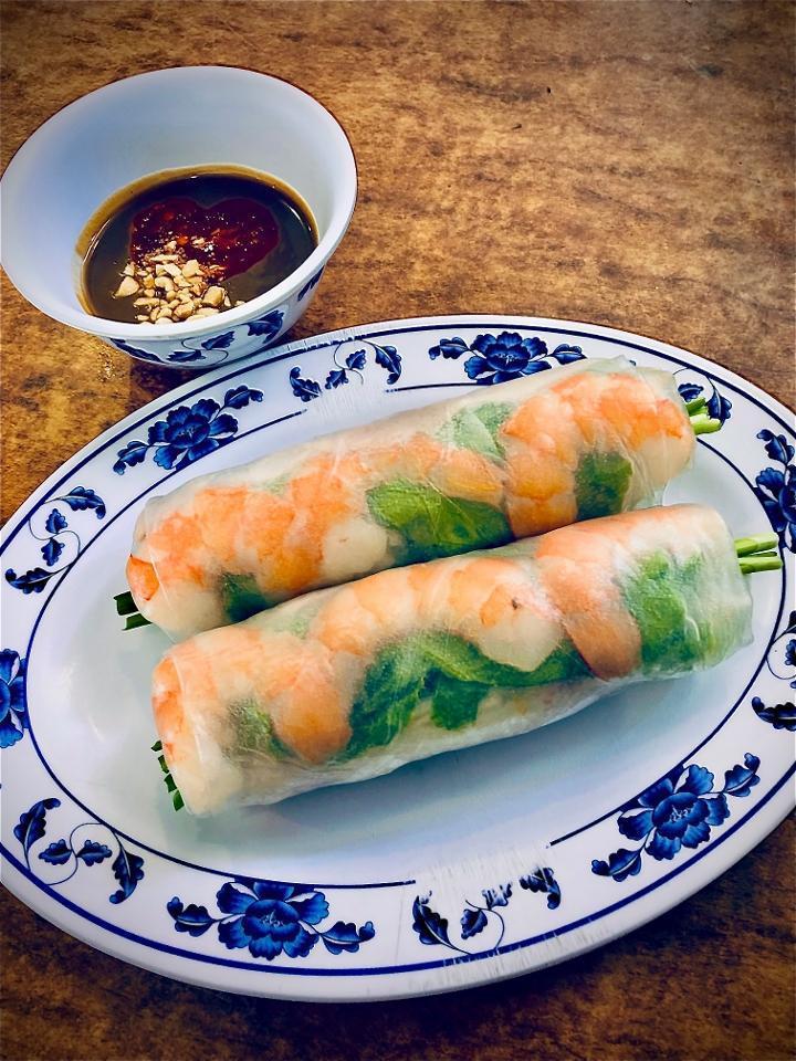 Shrimp Spring Rolls · Fresh | shrimp, vermicelli noodles,  lettuce, cucumber, cilantro, mint & basil hand-rolled in fresh rice paper, served with a side of our signature house-made peanut sauce. . Allergens: spring roll: shellfish / peanut sauce: peanuts, wheat