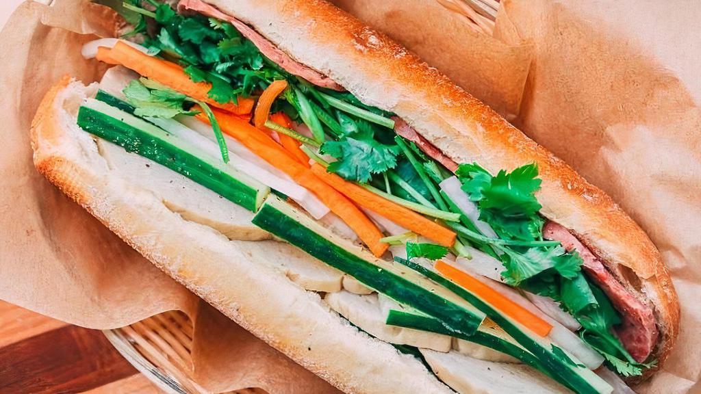 Banh Mi - The Og Cold Cut · Our version of the classic Banh Mi Thit Nguoi | Vietnamese ham & head cheese in a delicately crispy French baguette layered with mayo, onions, jalapenos, cucumbers, cilantro, & pickled daikon & carrots. Allergens:  wheat