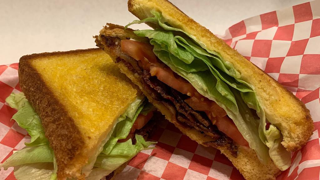 L. T. · Bacon, lettuce, tomato, & mayonnaise on texas toast served with pickles & a bag of chips.