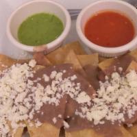 Nachos Cancún / Cancún Nachos · Nachos layered with refried beans, diced tomatoes, topped with cheese. Served with sour crea...