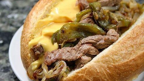 Philly Cheese Steak · Grilled top sirloin with grilled peppers & onions and topped with American-swiss & cheddar cheese sauce. Served on a toasted hoagie roll.