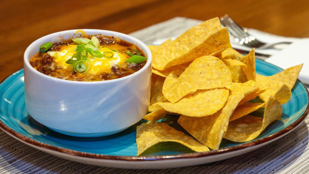 Beef Chili Bowl & Chips · Beef Chili topped with Sour Cream, Cheddar Cheese, and Green Onions. Served with a side of Tortilla Chips. Chili contains Beef, Red Kidney Beans, Peppers, Tomato.