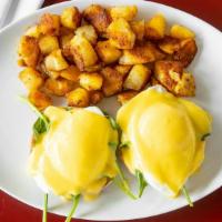 Eggs Florentine · Two poached eggs on an English muffin, over baby spinach dressed with hollandaise sauce, ser...