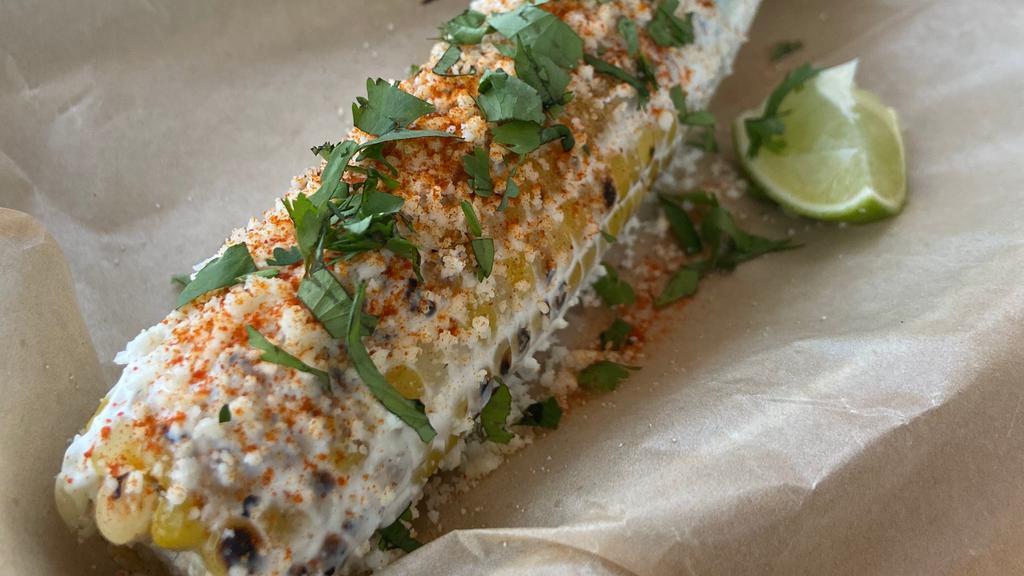 Elote · Grilled corn on the cob slathered in a mixture of  crema, chili-lime powder and cotija cheese [V][GF].