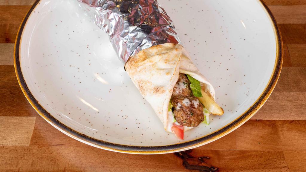 Kabab Sandwich · Grilled ground lamb, seasoned to perfection wrapped in pita bread with lettuce, tomatoes, and tahini sauce.