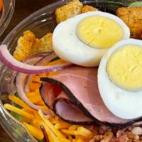Cobb Salad · Proteins like bacon, ham, and boiled eggs. Mixed with tomato, red onions, cheddar cheese, an...