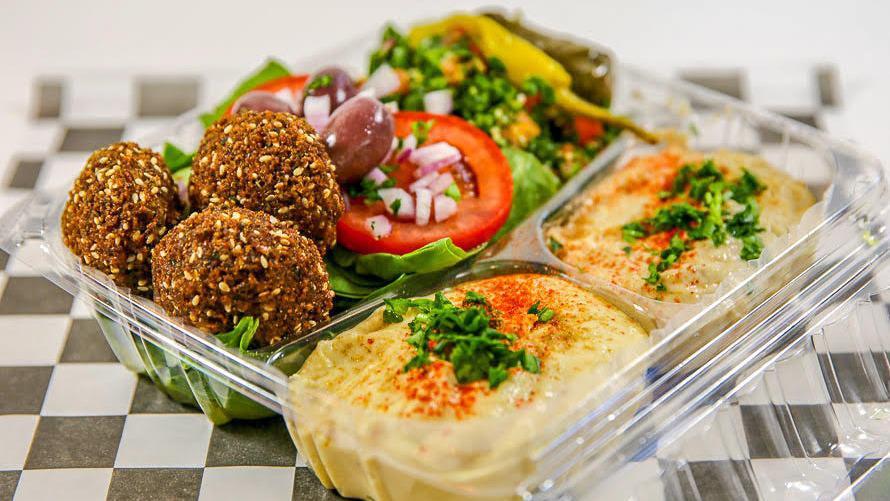 Veggie Combo Platter · Three falafel balls, hummos, Baba ghanouj, tabouly, spinach salad, stuffed grape leaves, and pita bread. Made from ground chickpeas with parsley, onions, garlic, cumin, and coriander then deep fried in the shape of a meatball.