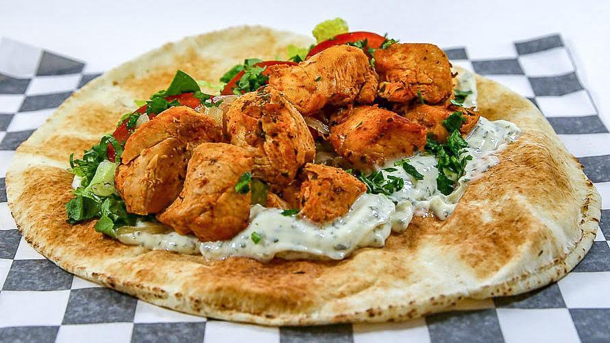 Chicken Shish Tawook Sandwich · Grilled chicken with sauteed onions, lettuce, tomatoes, garlic sauce, and parsley. Wrapped in pita bread.