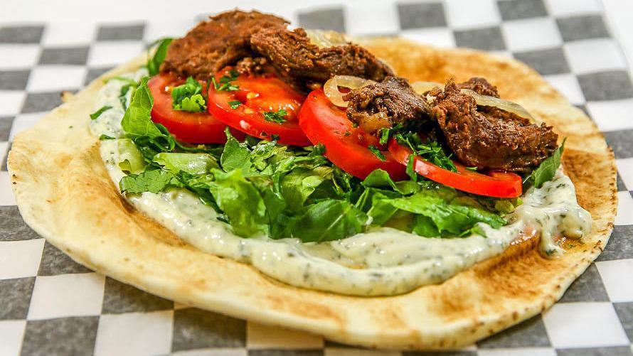 Beef  Shawarma Sandwich · Beef shawarma style with sauteed onions, lettuce, tomatoes, garlic sauce, and parsley. Wrapped in pita bread.