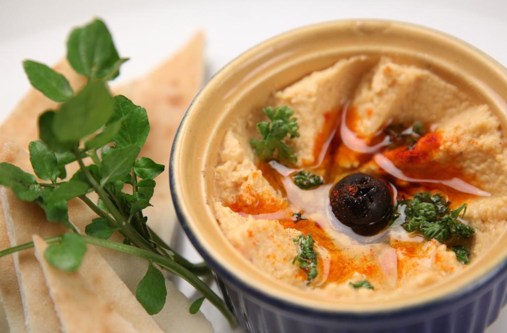 Hummus · chick pea puree, topped with roasted peppers and kalamata olives, served with fresh pita.