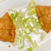 Samosa · deep-fried pastry triangles stuffed with spiced potatoes and green peas. two per order