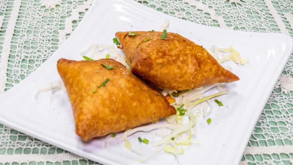 Vegetable Samosa · A crispy pastry stuffed with mildly spiced potatoes and peas.