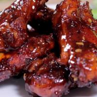 Chicken Wings W. Garlic Sauce (8 Pieces) · Cooked wing of a chicken coated in sauce or seasoning.