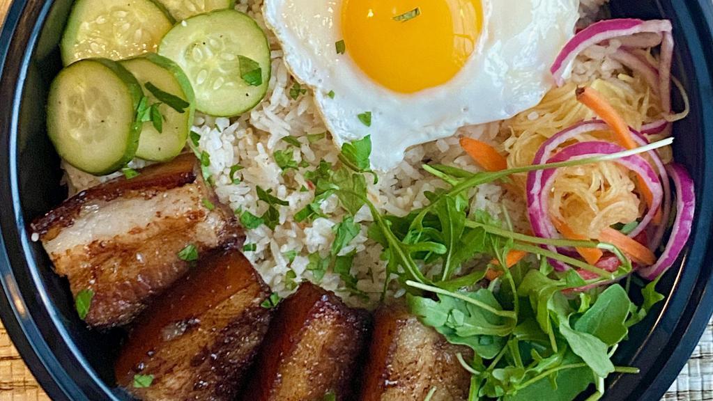 Pork Belly Adobo Rice Bowl · Pork belly braised in soy sauce and spices, pickled papaya and cucumbers, fried egg, garlic fried rice, cilantro.