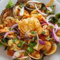 Combinación De Mariscos / Seafood Mix · Langosta rellena de callo, camarones. Servida con arroz y vegetales frescos. / Lobster stuff...