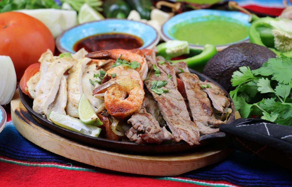 Fajitas Mixtas · Seasoned and grilled chicken, steak, and shrimp cooked with bell pepper, onion and tomato. Served with sour cream, rice, guacamole, tortillas and salad.