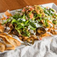 Nachos Texanos · Sautéed onions, jalapeños and chihuahua cheese, comes with lettuce, sour cream, guacamole, m...