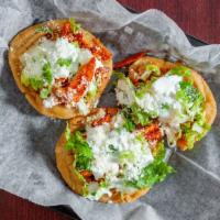 Sopes (2Pc) · A home made fried soft corn tortilla with beans, lettuce, onions, sour cream & queso cotija ...