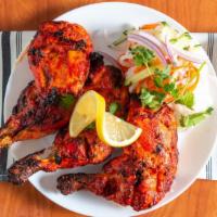 Tandoori Chicken · Chicken drumsticks marinated in ginger, garlic, yogurt, spices and broiled over a fire in ou...