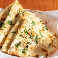 Garlic Naan · Leavened white flour dough topped with garlic, cilantro and baked in a clay oven.