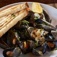 Mussels · White wine butter sauce with leeks carrots and parsley on a grilled sourdough.