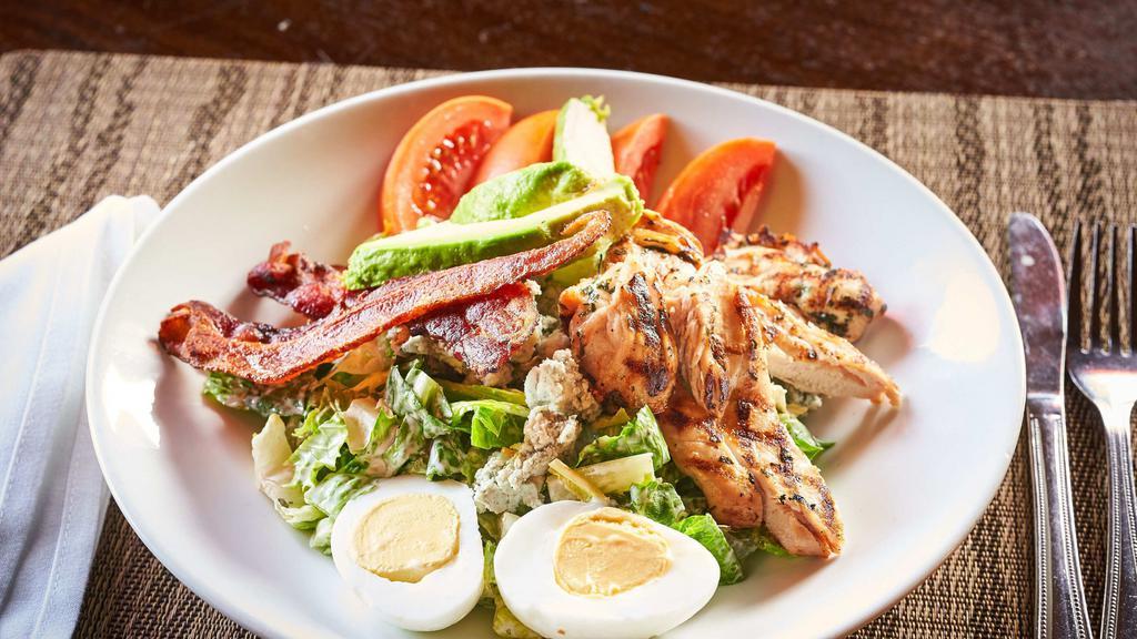 Cobb Salad · Chopped romaine, grilled chicken, hard boiled egg, avocado, blue cheese crumble, bacon and tomato with buttermilk herb dressing.