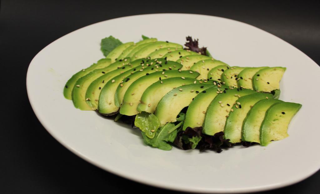 Avocado Salad · Green lettuce with slices avocado on the top with ginger dressing.