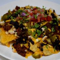 Chili Nachos · Corn tortillas chips topped with melted cheese, chili, black beans, diced tomatoes and slice...