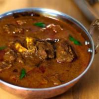 Goat Masala Curry · Goat cooked in onion, tomatoes and exotic spices.