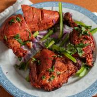 Tandoori Chicken · With leg and breast pieces of chicken marinated and barbecued in a clay oven. Served with ri...