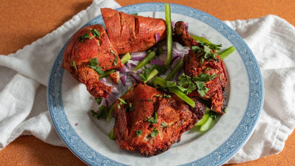 Tandoori Chicken · With leg and breast pieces of chicken marinated and barbecued in a clay oven. Served with rice.