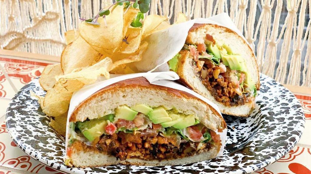 Vegan Torta · house pambazo sandwich filled w/pickled jalapeños, avocado, pico de gallo, black refried beans, lettuce, house-made vegan chorizo (mushroom & tofu), & cashew cream served on a french roll with a side of house-made chips and choice of filling (contains gluten , nuts, and soy)