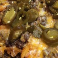 Nacho Waffle Fries · Topped with Beef, Cheddar Cheese, Tomatoes, Lettuce, Jalapeños, & Sour Cream, and Salsa on a...