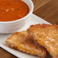 Grilled Cheese + Tomato Basil Soup · Bowl of tomato soup, basil grilled sourdough, aged gruyere, gouda, and cheddar.