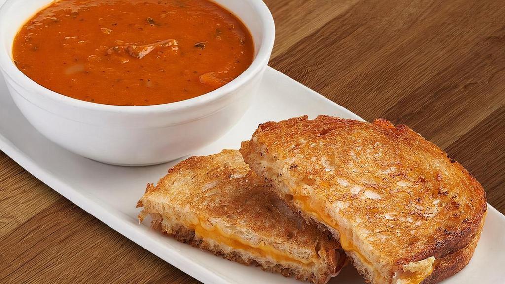 Grilled Cheese + Tomato Basil Soup · Bowl of tomato soup, basil grilled sourdough, aged gruyere, gouda, and cheddar.