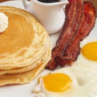 Buttermilk Pancakes + Eggs + Meat · Two cakes with choice of eggs and meat.
