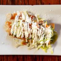 Flautas · Corn tortillas stuffed with shredded chicken, topped with green, and red salsa. Garnished wi...