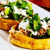Sopesitos · Gluten free corn patties topped with refried beans, chopped lettuce, queso fresco, and salsa...