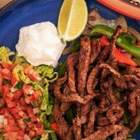 Fajitas · Peppers and onions mixed with meat served with lettuce, pico de gallo and sour cream on the ...
