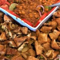Samosa Chaat · Savory veggie samosas mixed with chickpea curry and topped with onions, yogurt, mint and tam...