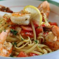 Shrimp Scampi · Sauteed shrimp with onions, garlic, olive oil, lemon, fresh basil and fresh tomatoes over pa...
