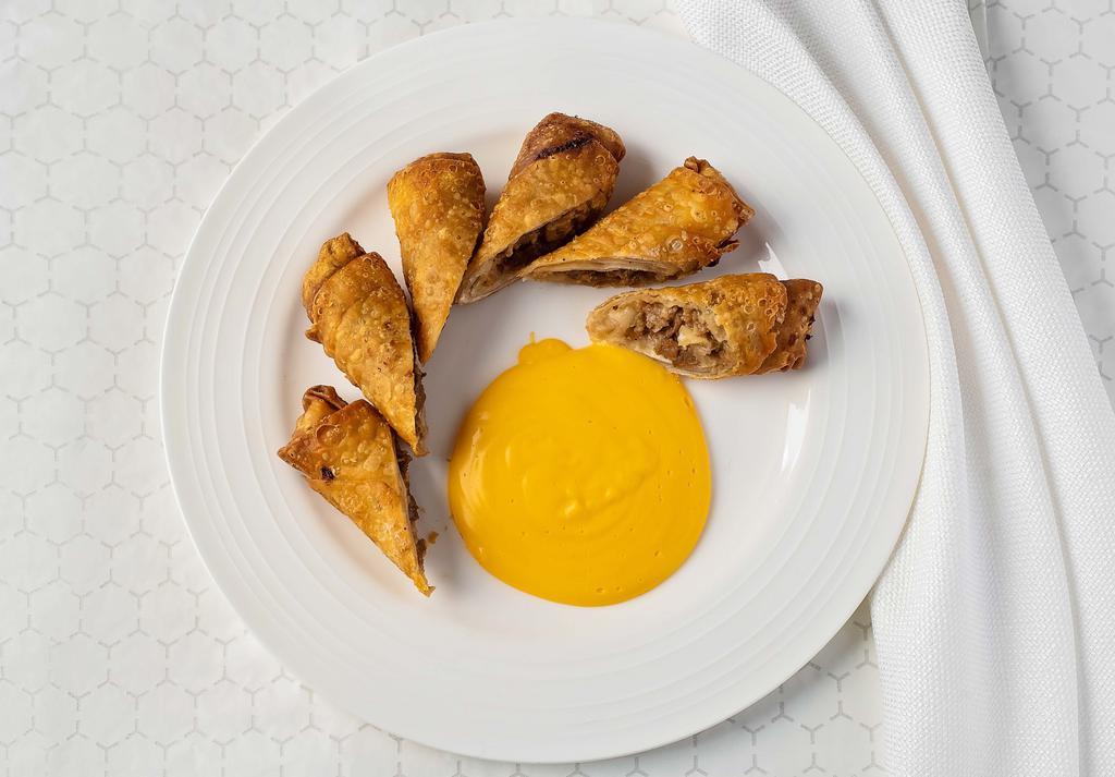 Cheesesteak Egg Rolls · Crispy egg roll filled with chipped steak served with a side of cheese wiz.