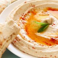 Humus · Mashed chickpeas flavored with garlic, lemon juice and tahini served with pita bread