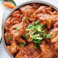 Goat Karahi  · Goat Cooked in Tomato Gravy with herb and Spices Comes with Aromatic Basmati Rice.