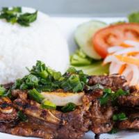 Grilled Beef Short Rib Rice Platter · Served with pickled carrots and daikon, tomato, cucumber, and garnished with scallions. Come...