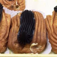 Eclairs · Pastry shell filled with vanilla custard and topped with a stripe of chocolate fudge.