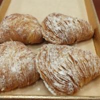 Sfogliatelle · Flaky pastry filled with a citrus flavored cheese and chunks of citron sprinkled with powder...