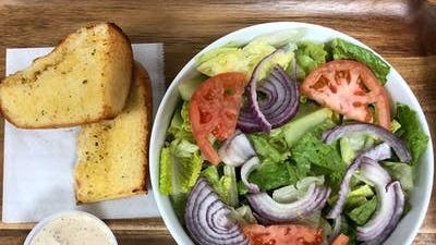 Tossed Salad · House salad. Made with romaine lettuce, tomato, red onions, green peppers, cucumbers, kalamata olives and hard boiled egg. Served with tasty garlic bread.